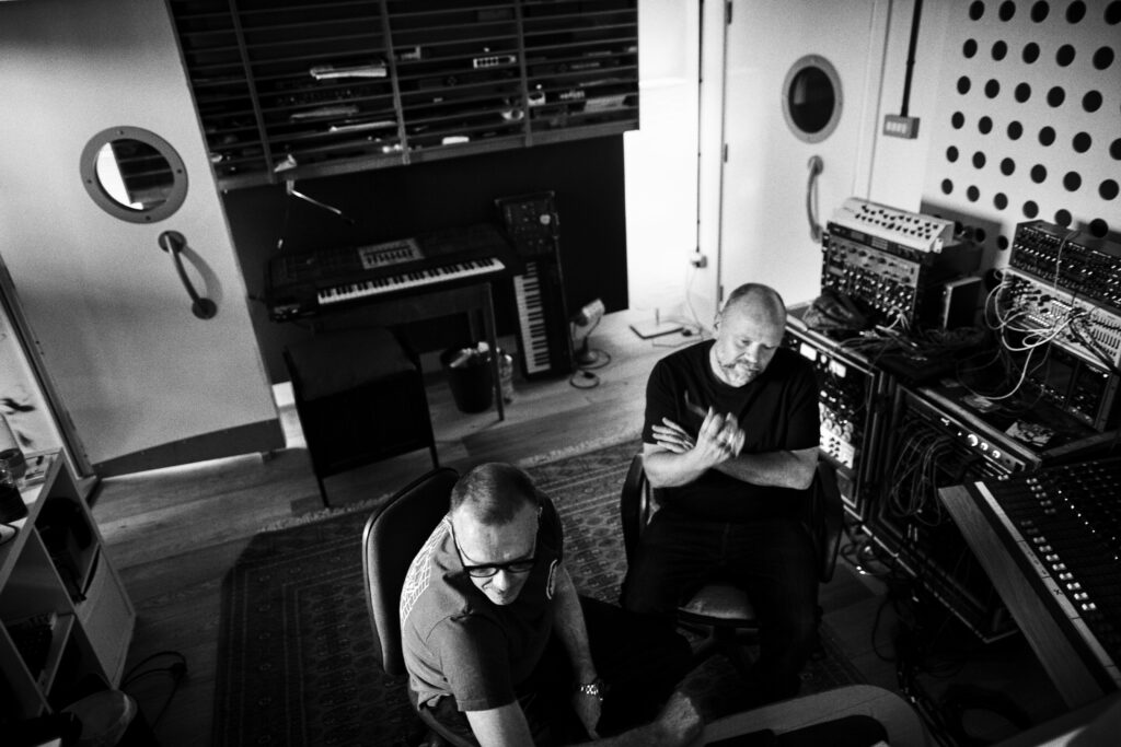 Svartvit bild på två män som sitter i en ljudstudio.