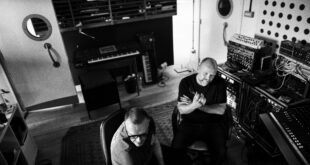 Svartvit bild på två män som sitter i en ljudstudio.