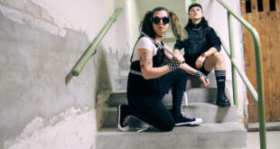 Lizzy och Emma i The Guilt sitter i en betongtrappa.