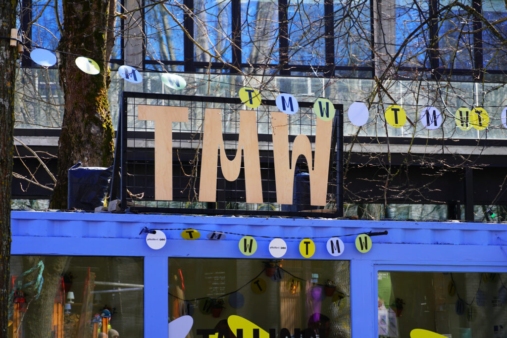Skylt med texten TMW på en liten byggnad som innehåller en informationsdesk.